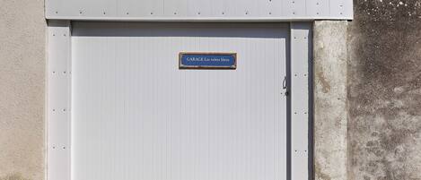 A closed garage door with a sign reading 'GARAGE Les voltes bleus.'