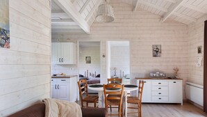 A cozy interior with a dining area, wooden walls, and a kitchen. - Gîte Nature and Spa - Oisly (Oisly)