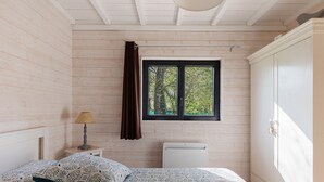 A bedroom with a bed, a window, a radiator, and a wardrobe. - Gîte Nature and Spa - Oisly (Oisly)