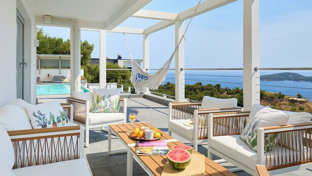 A terrace with white furniture, a hammock, and a view of the sea. - Hedera Estate, Villa Hedera XXII (Zaton Mali)