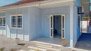 A single-story house with a red-tiled roof, a front door, and a small porch area. - Villa Di Mare II-Piscina e churrasqueira (São Francisco do Sul)