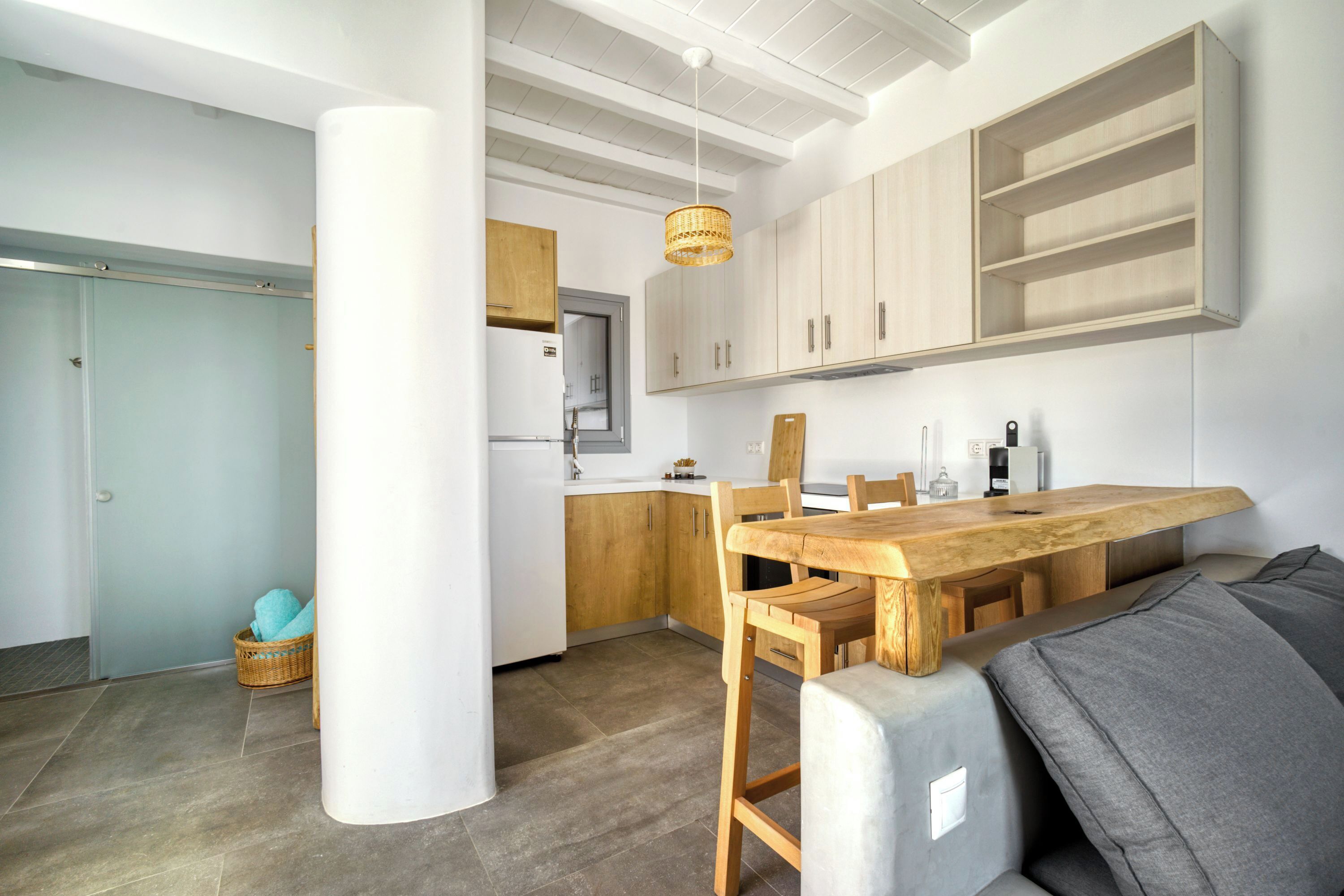Une cuisine moderne avec des meubles en bois, une table à manger et un luminaire suspendu.