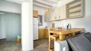 Une cuisine moderne avec des meubles en bois, une table à manger et un luminaire suspendu.