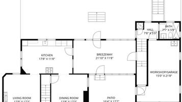 Grundplan der viser en patio, køkken, spisestue, stue, entre, gang, forbindelsesgang, badeværelse og værksted/garage.