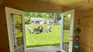 A room with a wooden floor, a door leading outside, and a set of dumbbells on the right. - Private Luxurious Canal Estate (Princeton)