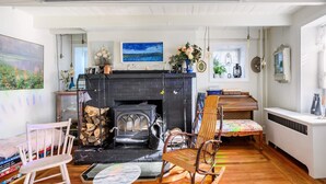 Een knusse woonkamer met een open haard, houten meubels en uitzicht op de omgeving.