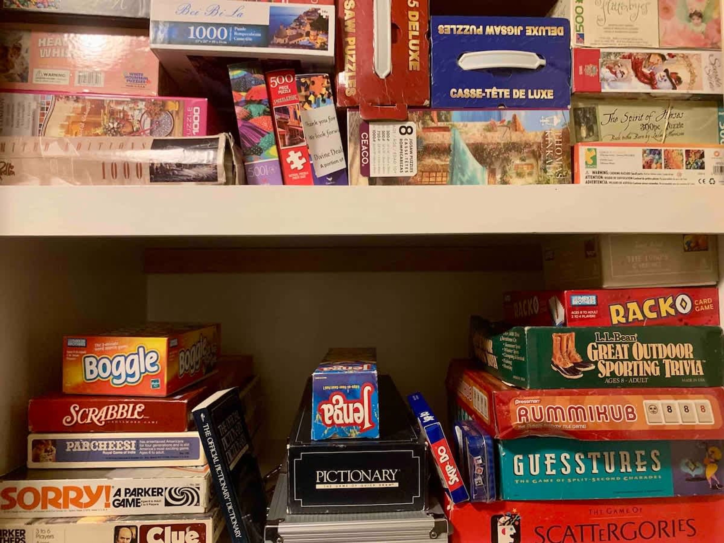 Een plank vol met verschillende bordspellen en puzzels.