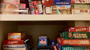 Een plank vol met verschillende bordspellen en puzzels.