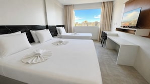 A hotel room with two beds, a desk, a TV, and a city view. - Atlas Beach Hotel (Fortaleza)