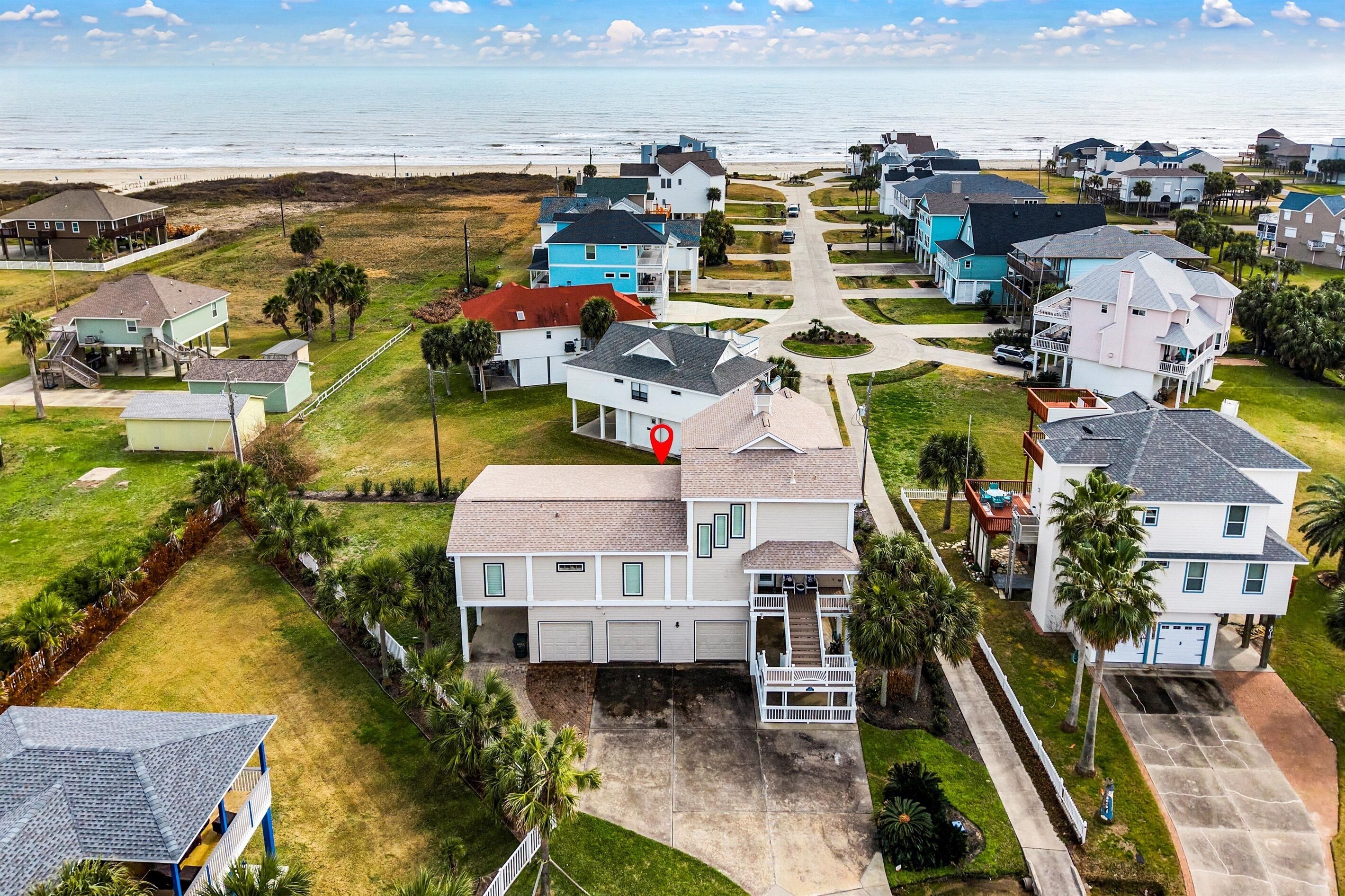 Zona residencial costera con casas, una playa y cielo despejado.