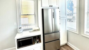 A kitchen with white cabinetry, a stainless steel refrigerator, and a built-in microwave. - 7 mins walk to Boardwalk & Beach! AC & Beach Tags! (Ventnor City)