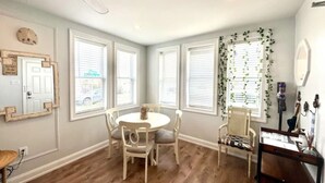 A room with a round table and four chairs, large windows with blinds, a ceiling fan, and a wall-mounted mirror. - 7 mins walk to Boardwalk & Beach! AC & Beach Tags! (Ventnor City)