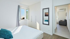 A modern bedroom with a bed, a window, a wardrobe, and a mirror. - Hedera Estate, House Hedera III (Dubrovnik)