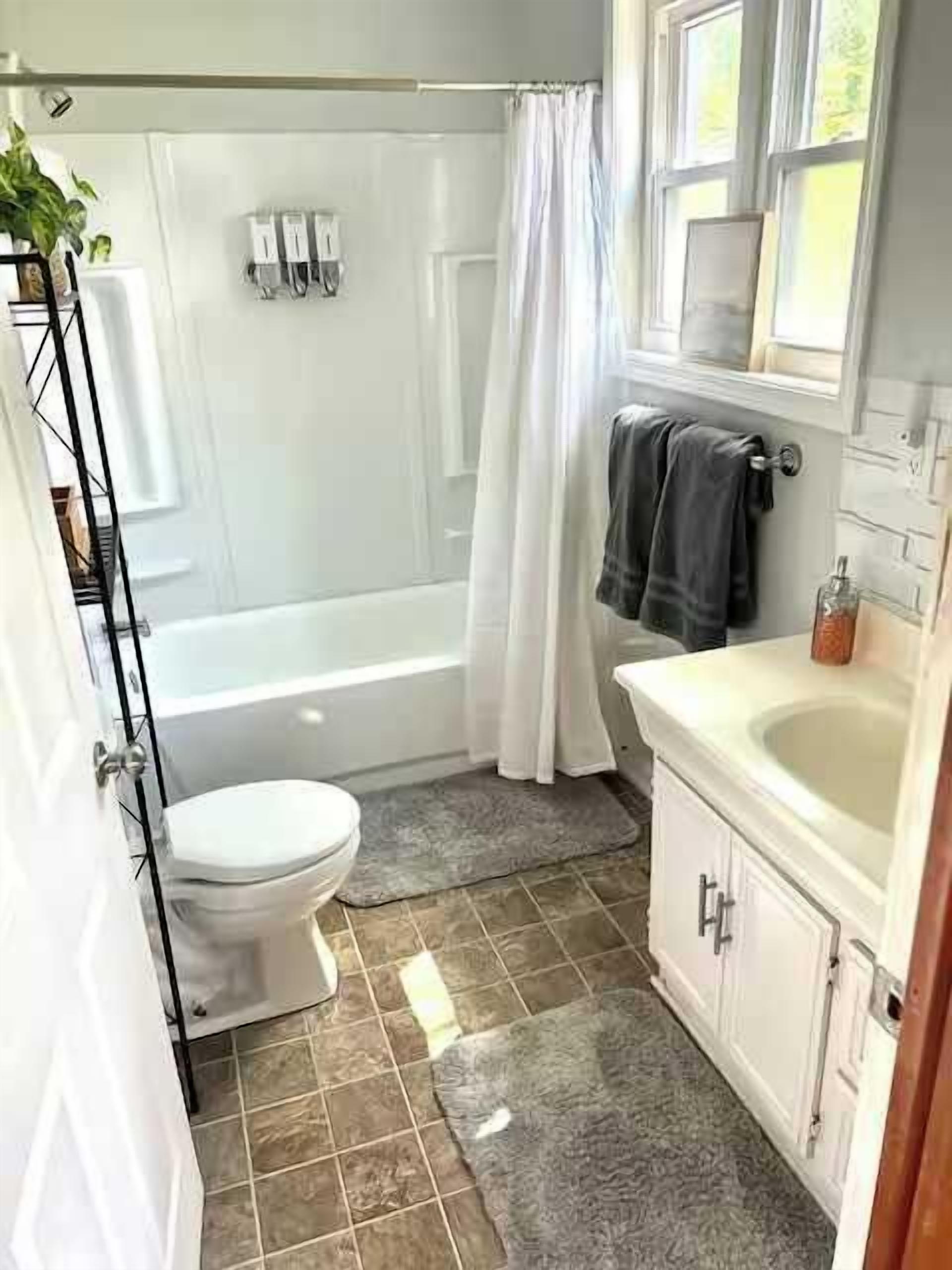 A bathroom with a bathtub, toilet, and sink.