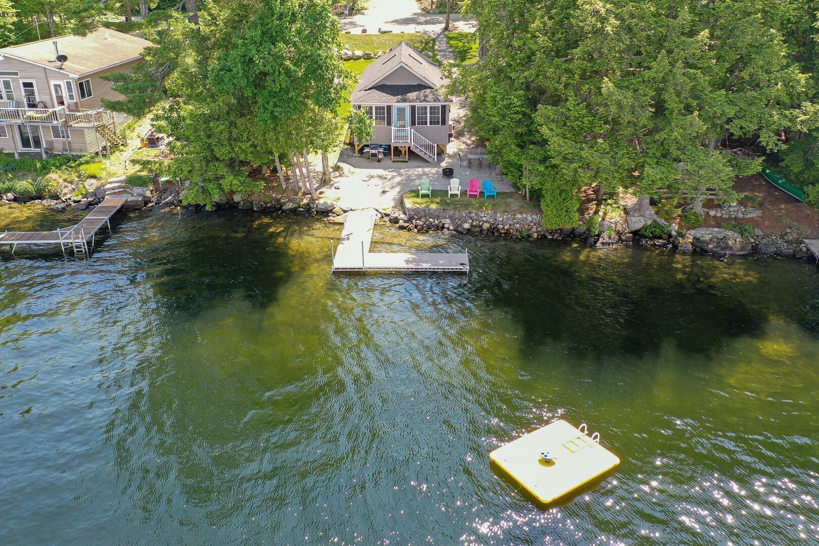 A riverside property with a dock, a house, and a boat.