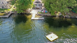 A riverside property with a dock, a house, and a boat.
