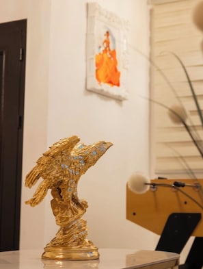 Una escultura dorada de un pájaro sobre una mesa.