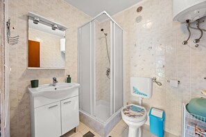 A bathroom with a shower enclosure, a sink, a toilet, and a mirror. - Sea View Apartment Ankica with Terrace (Kampor)