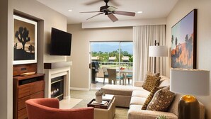 A modern hotel room with a fireplace, a flat-screen TV, a sofa set, a dining area with a table and chairs, and a balcony with a view. - Westin Mission Hills Resort Villas – 1BR Premium – March 7–14 2026 – Owner Week (Rancho Mirage)