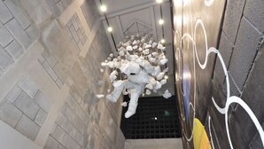 A staircase with a unique art installation featuring numerous white objects.