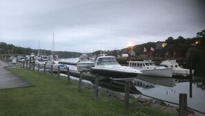 A marina with boats docked along a grassy waterfront.