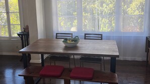 Ein Essbereich mit einem Holztisch, Bänken und einer Chandelüstere.