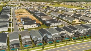Un barrio residencial con varias casas, un campo abierto y una piscina.
