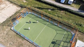 An aerial view of a tennis court with a surrounding fence and adjacent grassy areas. - Carva - Confort 1 TV - 2p (La Guérinière)