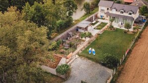 Luchtbeeld van een woonwijk met een huis, een tuin en een rivier.