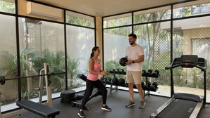 A gym with exercise equipment, large windows, and a treadmill. - Pool Rooftop Gym Tulum 2BR Penthouse A5 (Tulum)