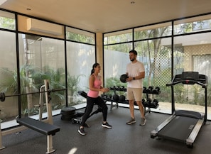 A gym with exercise equipment, large windows, and a treadmill. - Pool Rooftop Gym Tulum 2BR Penthouse A5 (Tulum)