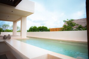 Ein moderner Poolbereich im Freien mit freiem Blick auf den Himmel und die umliegende Grünfläche.