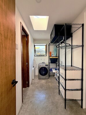 A laundry room with a washing machine, shelves, and a door. - House with Pool in Punta de Mita (Corral del Risco)