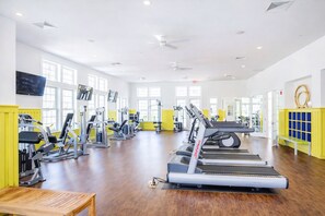 Un gimnasio con cintas de correr, máquinas de pesas y colchonetas de ejercicio.