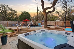 Ett bubbelbad med ett trädäck, en basketkorg och en liten pool.