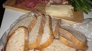 Een charcuterieplank met plakken vlees, kaas en brood, voor een knusse achtergrond van een open vuur.