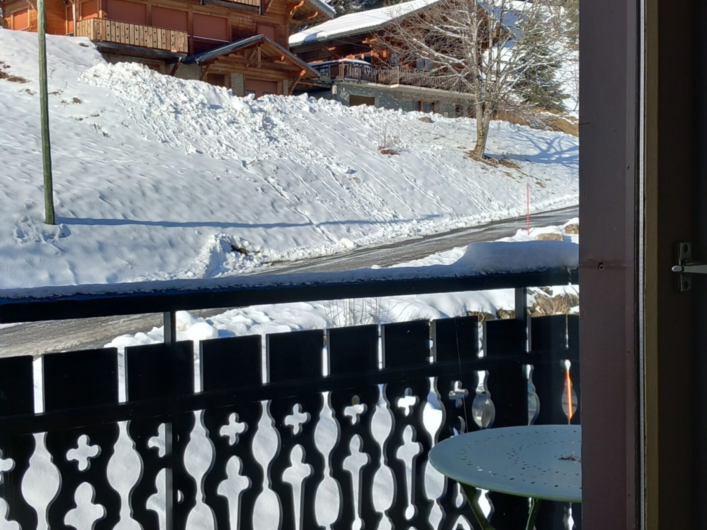 Montaña nevada con un edificio de madera al fondo.