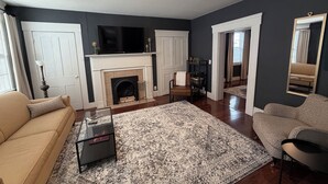 A living room with a fireplace, a sofa, a coffee table, and a patterned rug. - A stylish and quiet, comfortable space with full house accommodations (Chillicothe)