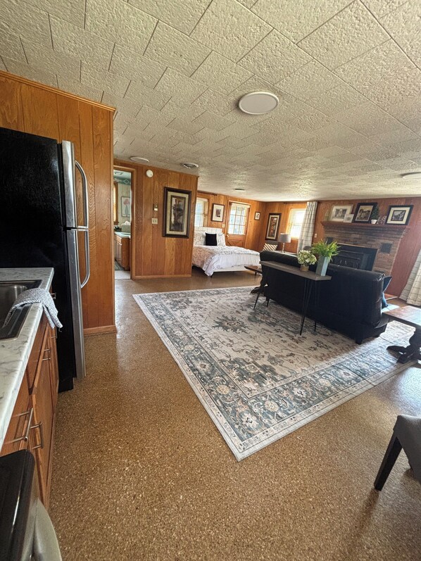 A compact living space with a kitchenette, a dining area, and a bedroom.