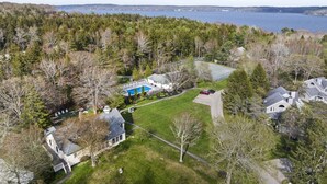 A residential area with a large house, a swimming pool, and a view of a lake. - Amore | Romantic Coastal Cottage Near Spruce Point (Boothbay Harbor)