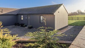 A single-story building with a dark exterior, a sloped roof, and a small porch area. - Fleetwood (Richmond)