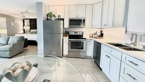 A modern kitchen with white cabinets, a refrigerator, a microwave, an oven, and a sink. -  The Coastal - Gulf View 8th floor condo at Bonita Springs Beach & Tennis Club (Bonita Springs)