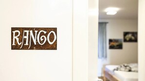 Ein Zimmer mit einem Bett, einem Fenster und einer Wand mit dem Wort 'RINGO'.