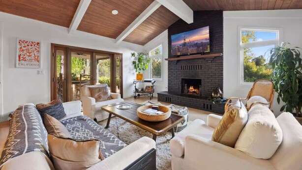 A spacious living room with a fireplace, comfortable seating, and a large TV screen. - Private Estate: House + Cottage, Pool & Tennis (Ojai)