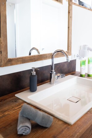 A bathroom with a wooden vanity, a white sink, and a mirror. - Selma vacation chalet in Essing - space for 2 to 4 people, ideal for families! (Essing)