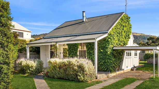 A house with a covered porch, a chimney, and a garden with well-maintained grass and shrubs. - The Pilots Cottage in Apollo Bay (Apollo Bay)