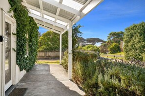 A covered outdoor area with a concrete pathway leading to a house. - The Pilots Cottage in Apollo Bay (Apollo Bay)