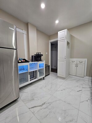 A kitchen with a refrigerator, a coffee maker, and a cabinet with glass doors. - 2 BR- 2 br Retreat w/ King Loft, Near Downtown, Hospital and Sport Arena (Peterborough)