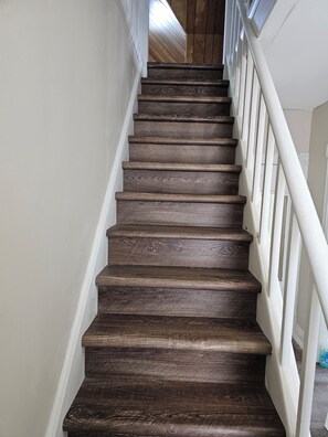 A wooden staircase with white railings. - 2 BR- 2 br Retreat w/ King Loft, Near Downtown, Hospital and Sport Arena (Peterborough)