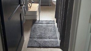 A bathroom with a bathtub, a sink, a toilet, and a window. - Roomy 2 Bedroom Apartment 20 Minutes from Philadelphia (glenolden)